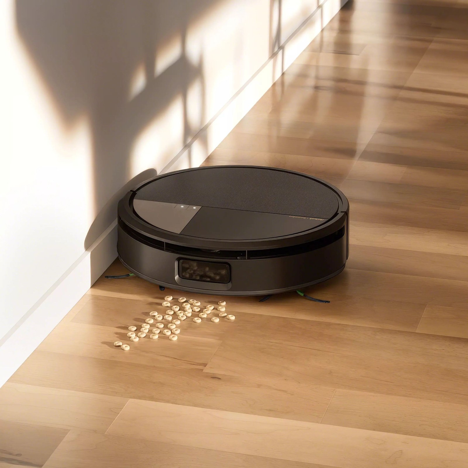 L'iRobot Roomba Max 705 Combo nettoie les céréales d'un parquet le long d'un mur