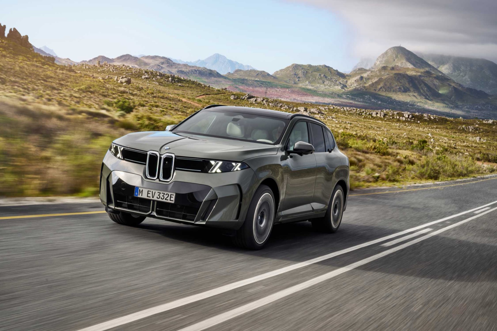 El nuevo BMW iX5 circulando por una carretera de montaña, vista frontal de tres cuartos