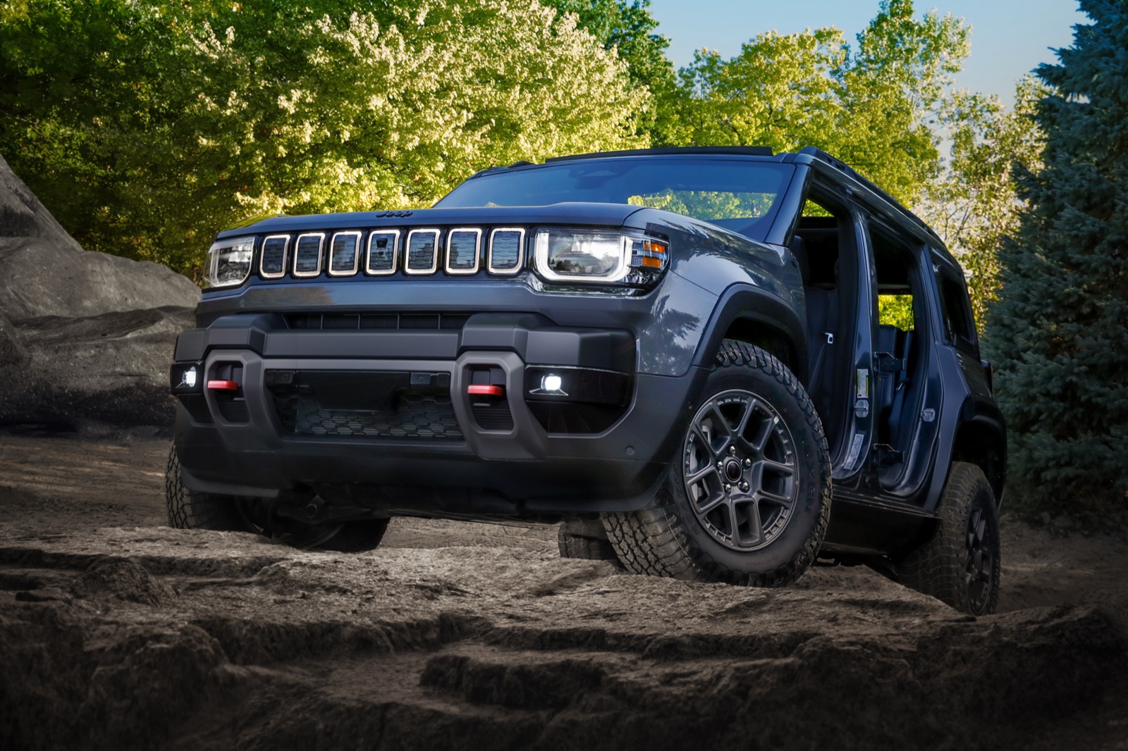 Jeep Recon EV 2026 gris sin puertas trepando rocas